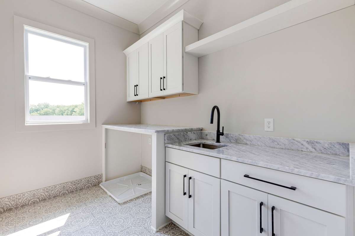 The large utility space offers ample counter space for folding clothes or storage, along with additional shelving and cabinet storage. 6369 Alamo Pl  Nashville, TN