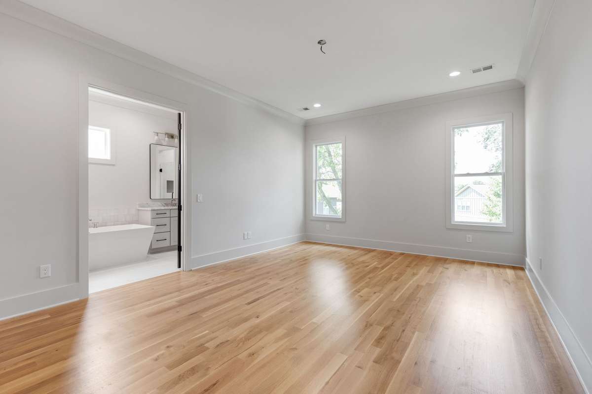 The upstairs primary bedroom is brightened by two single windows and adorned with light-colored hardwood floors. 6369 Alamo Pl  Nashville, TN