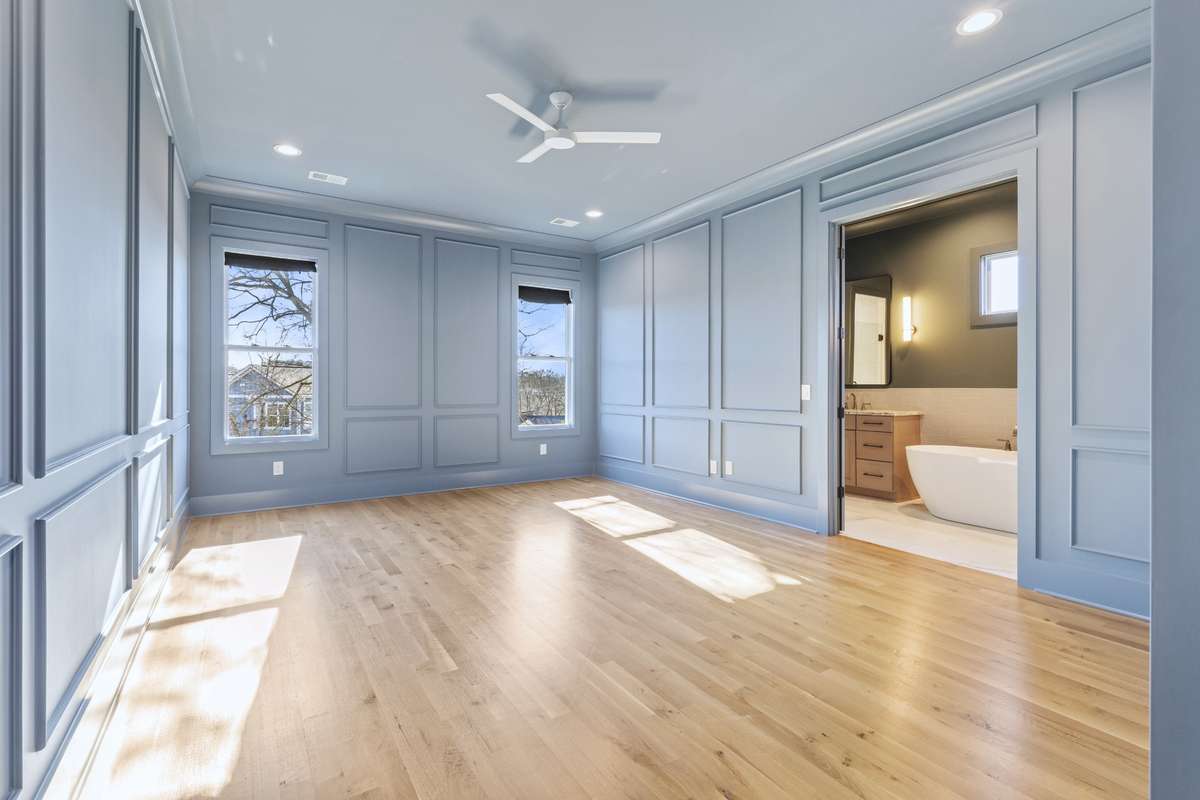 Stunning blue primary suite with crown molding, paneling trim, & hardwood flooring. 6371 Alamo Pl Nashville TN 37209