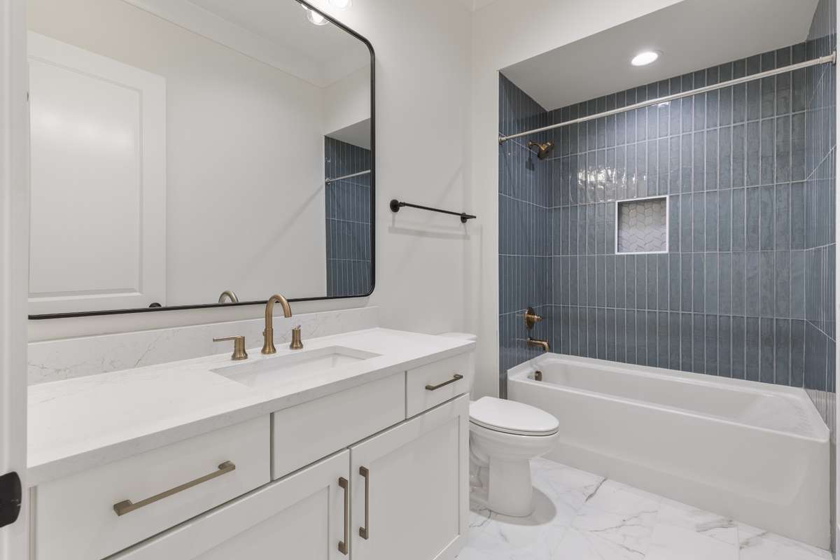 Private bathroom with oversized single vanity, tile floors, & blue tiled combo tub & shower. 6371 Alamo Pl Nashville TN 37209