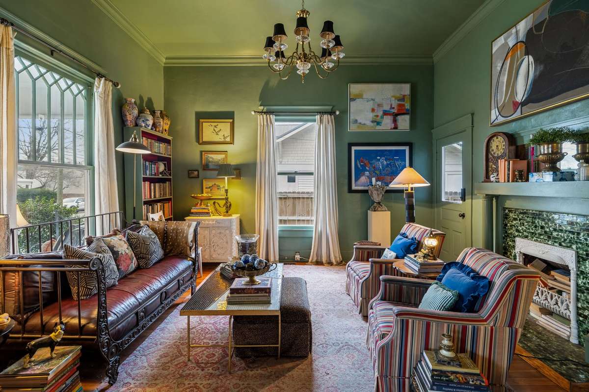 The front library, with leaded windows, original fireplace detailing, and separate access to your covered side porch