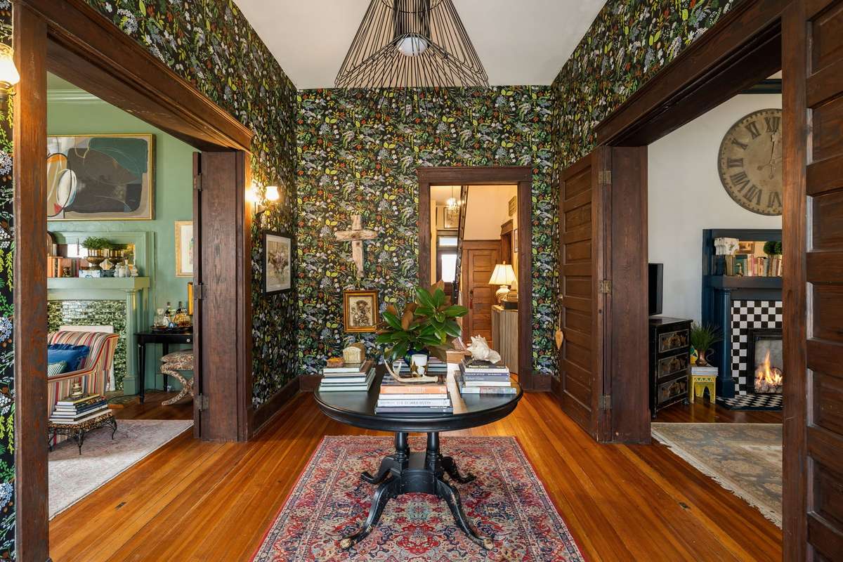 The grand foyer carries a bold first impression with large parlor doors that open to symmetrical living areas.
