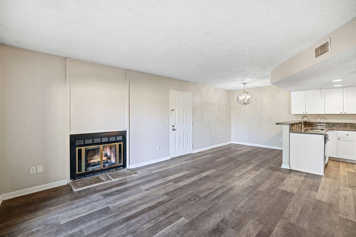 This spacious living room features a cozy fireplace and an abundance of natural light
