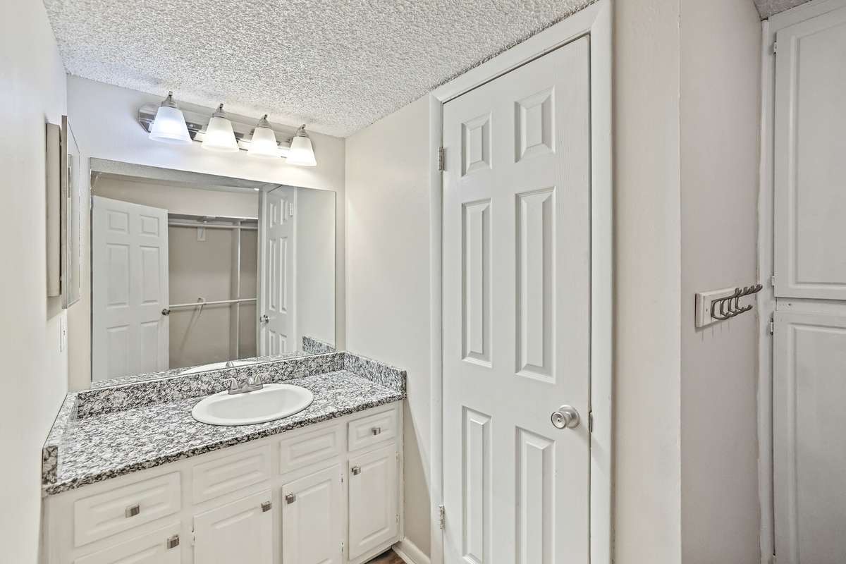 The primary bathroom features elegant granite countertops, adding a touch of luxury