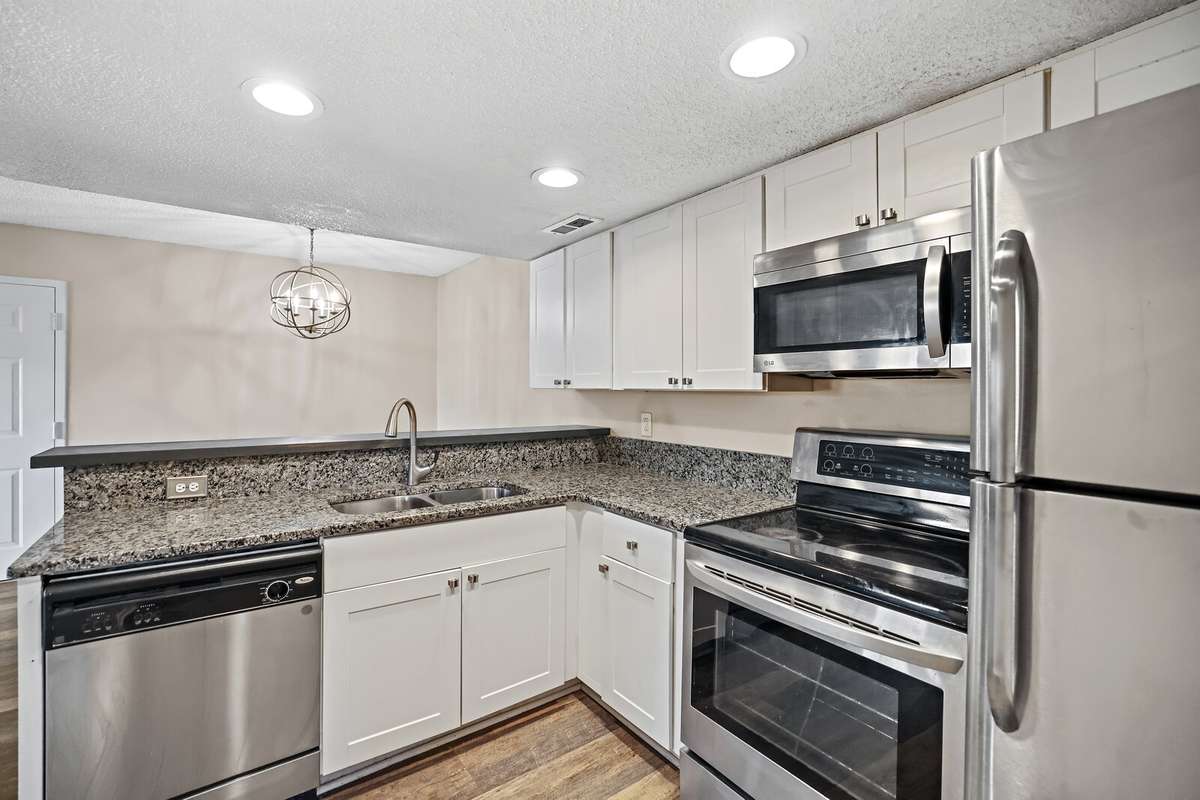 This bright, timeless kitchen features sleek stainless steel appliances, crisp white cabinetry and beautiful granite countertops, creating a clean, elegant space