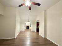 View of the living room, passing through morning/dining room and leading into the den with the fireplace