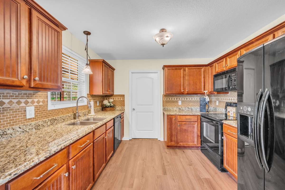 LARGE GALLEY KITCHEN.  DOOR LEADS INTO LAUNDRY/UTILITY ROOM, THEN GARAGE