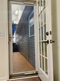 French door leading to the back deck also has a storm door. This room is off the den room with fireplace.