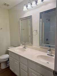 Owners bedroom has a door leading into double vanities. The bathroom also has a jetted tub with shower. Take note of the upgraded faucets and the beveled mirrors with decorative enhancements.