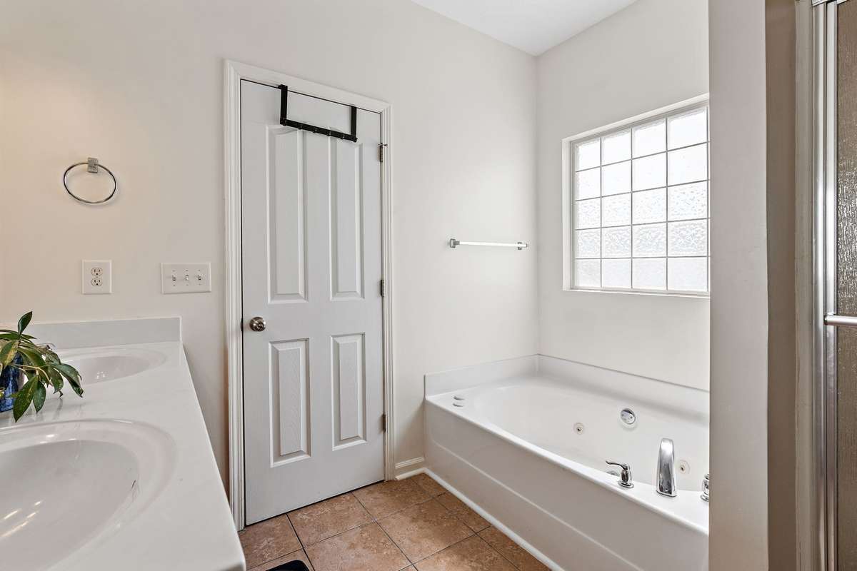 Large bathtub and separate shower in the primary bathroom.