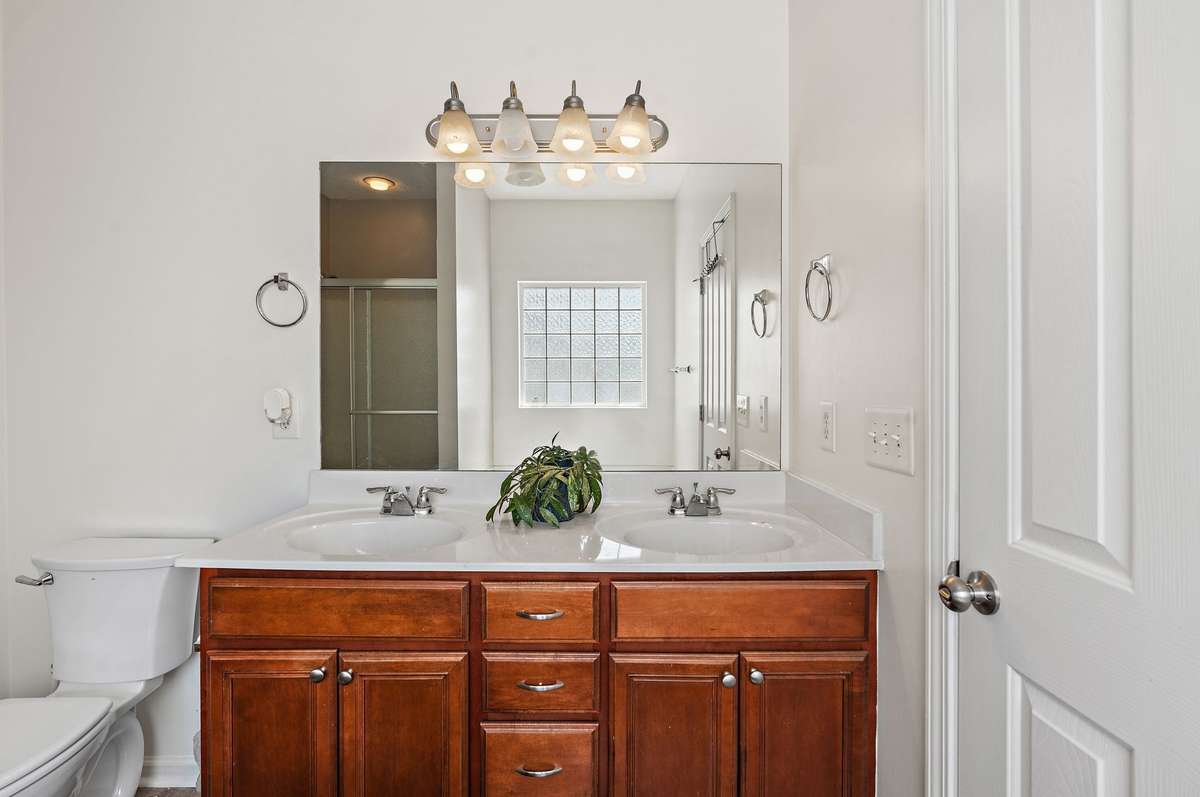 Primary bathroom with dual vanities.