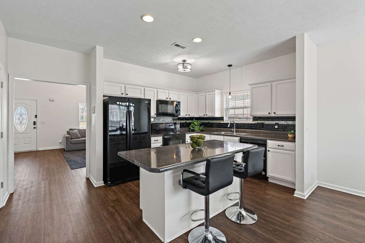Sleek eat-in kitchen with refreshed cabinetry and lighting.