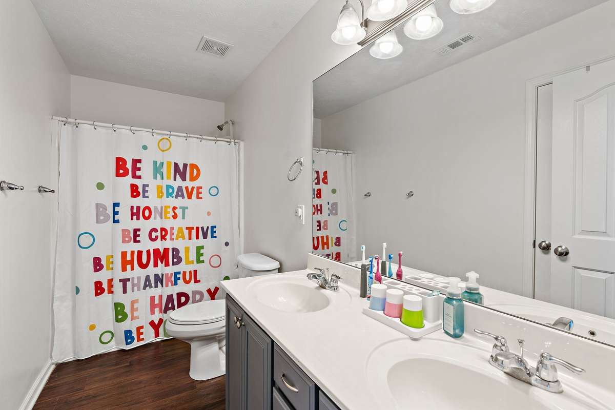 Full upstairs bathroom with dual vanities and shower/tub combo.