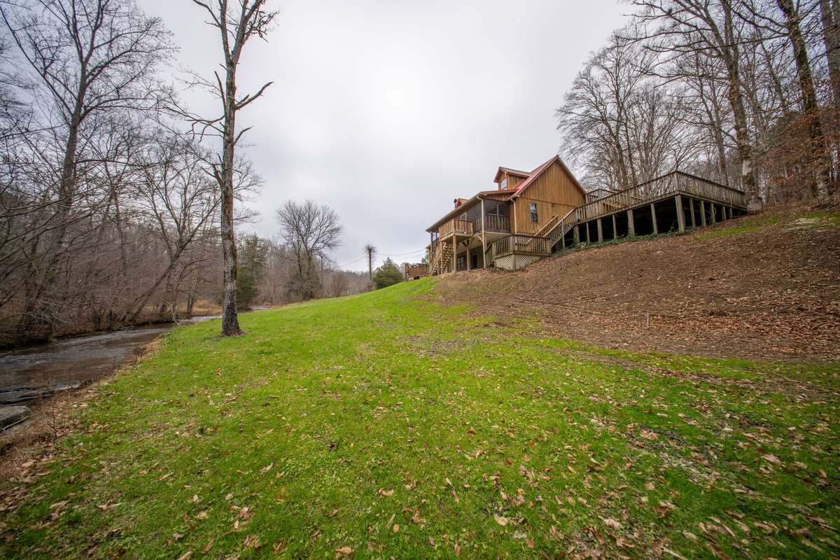 Beautiful cedar siding house sitting atop a gentle rise overlooking creek!