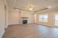 EXAMPLE>>>Large Living Room with a Stone Fireplace, Floating Wood Mantle, Double Tray Ceiling, and Tons of Natural Lighting!!