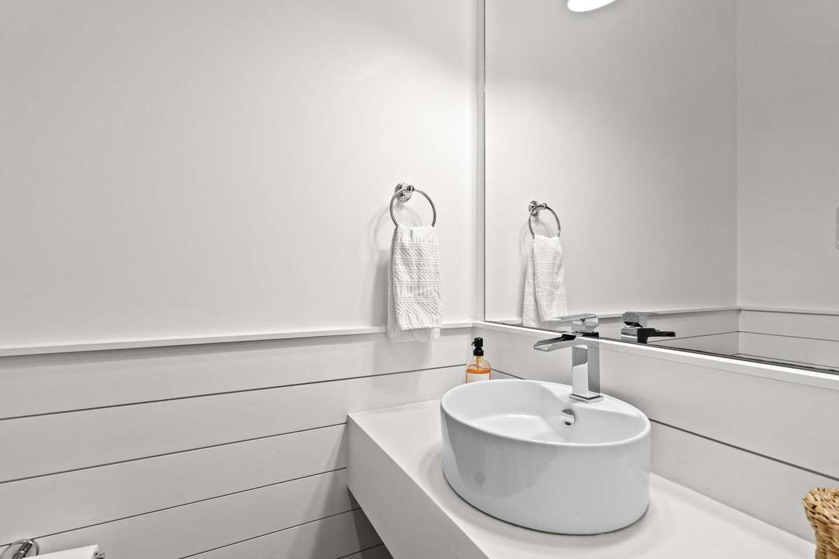 Half bath with shiplap detailing and a vessel sink,