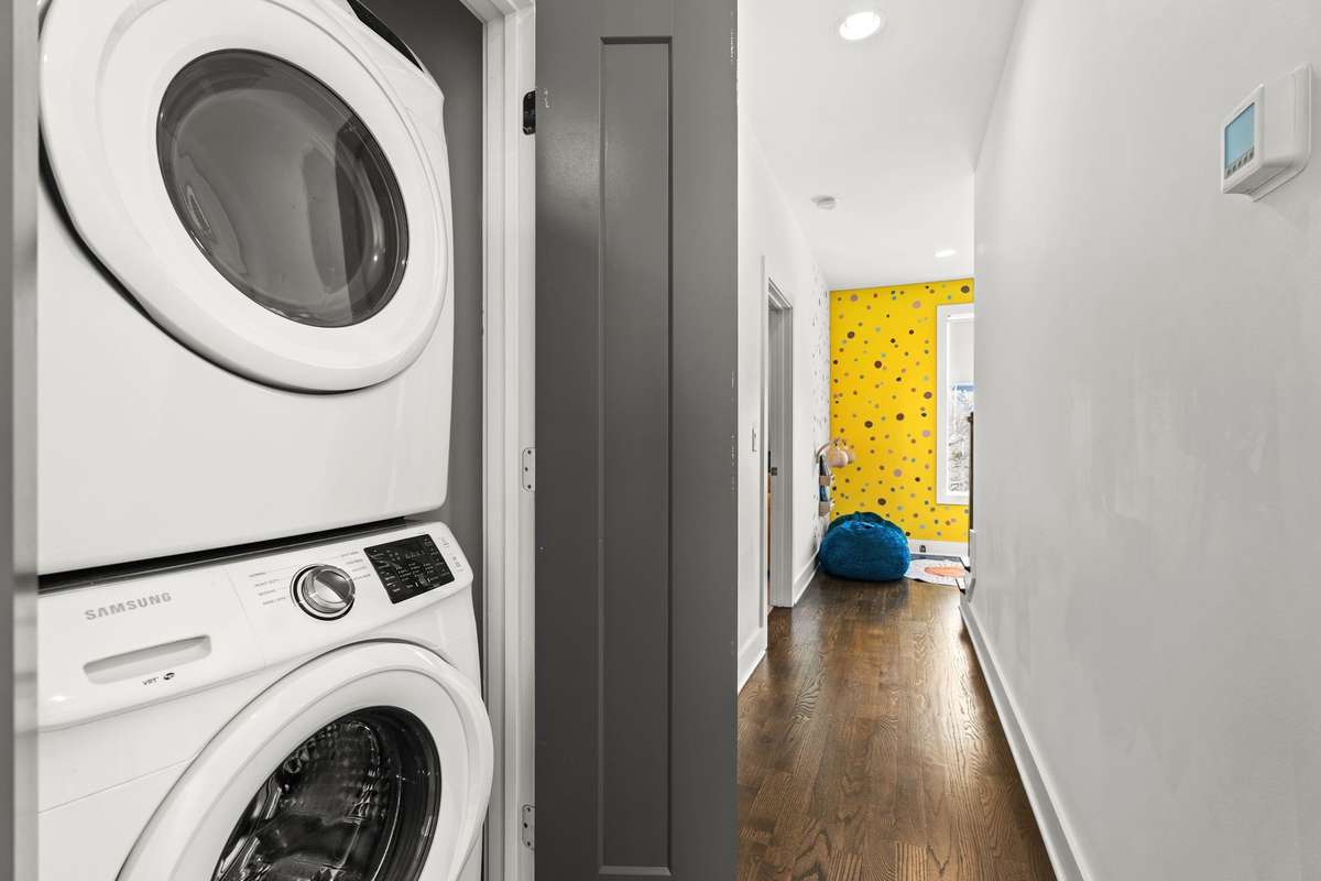 Stacked washer and dryer off hallway for easy access.
