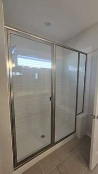 tiled walk in shower with a bench. 6ft shower glass door