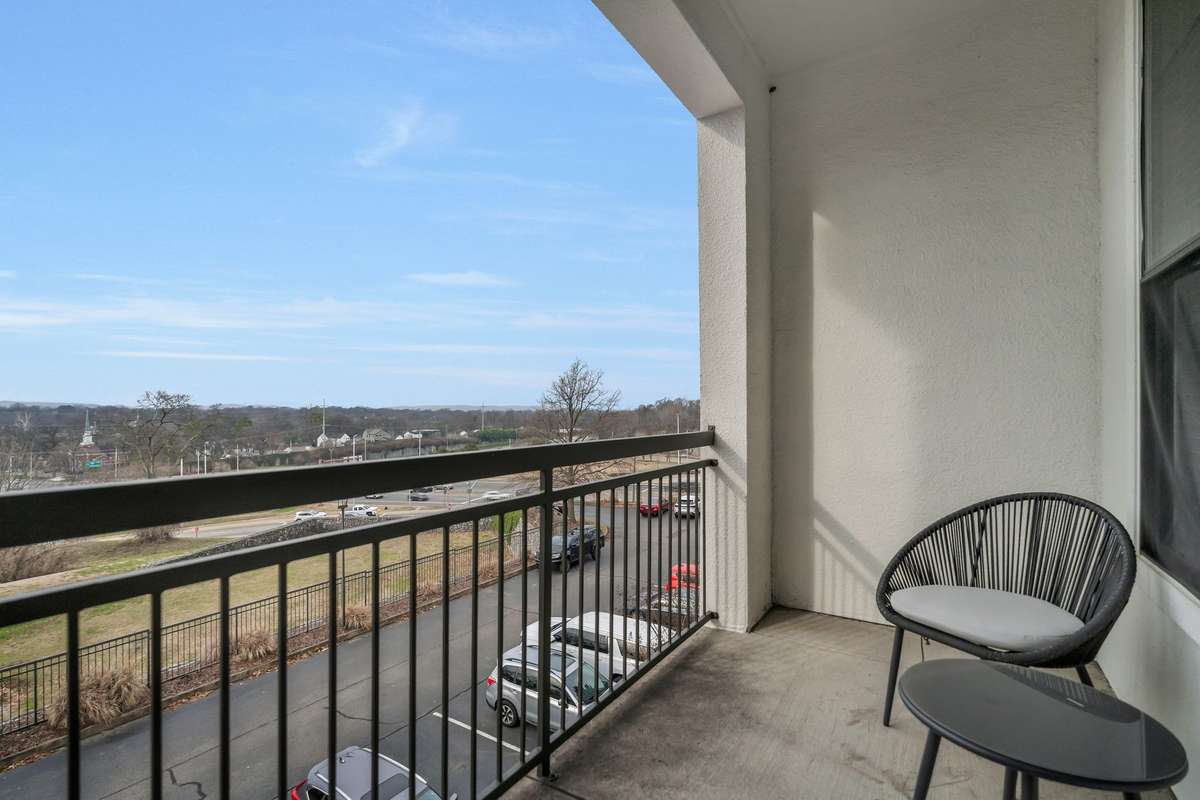 Covered balcony with railing and open views right off of the living room.