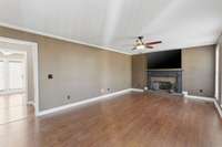 Living room leading into hallway to half bath and kitchen