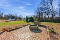 Extensive hardscape featuring a firepit, built-in grill surround, and wood pergola