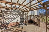 Extensive hardscape featuring a firepit, built-in grill surround, and wood pergola