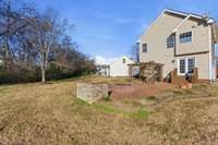 Extensive hardscape featuring a firepit, built-in grill surround, and wood pergola