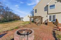 Extensive hardscape featuring a firepit, built-in grill surround, and wood pergola