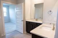 Owners bathroom suite features double vanities and upgraded tiled shower