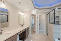 Amazing Primary Bathroom Features Tile Flooring, Recessed Lighting, a Gorgeous Double Tray Ceiling with Lighting, Crown Molding, a Tile Shower, Soaker Tub, Huge Double Vanity and a Toilet Room!