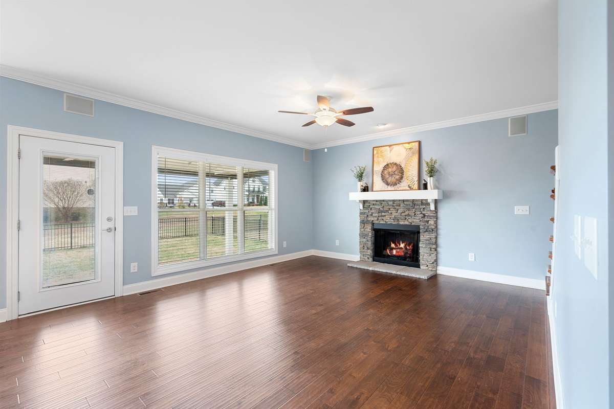 The natural gas fireplace is surrounded by beautiful stone accents and a crisp, white mantel...