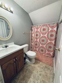 Upstairs full bathroom, and door to large storage space over garage