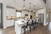 Photos are of the model home. Listing is for a to be built home. Exquisite Kitchen and Huge Island!
