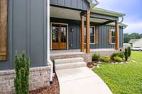 Fresh landscaping welcomes you to these gorgeous double front doors and cozy front porch!