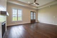 Living room boasting fireplace, ceiling fan, natural light and gorgeous double front door!