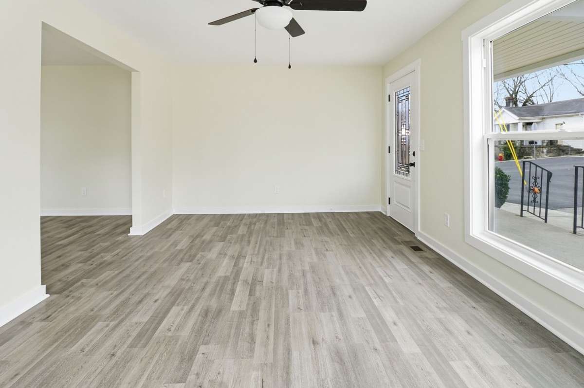 A sectional would fit comfortably in this space or divide with separate pieces and still have ample room. The neutral wall tone is perfect for whatever style of home you choose!