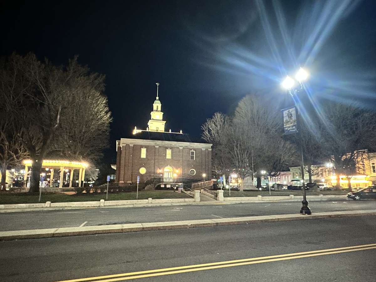 The beautiful Fayetteville city square at night. The night time lights are visible from the lawn giving a great view of downtown in the distance. Far enough away for quiet admiration and yet within walking distance.