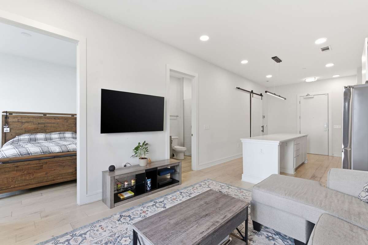 Living area viewpoint to dining island, bedroom and bathroom. Flex room / office is to the back covered by the sliding barn door.