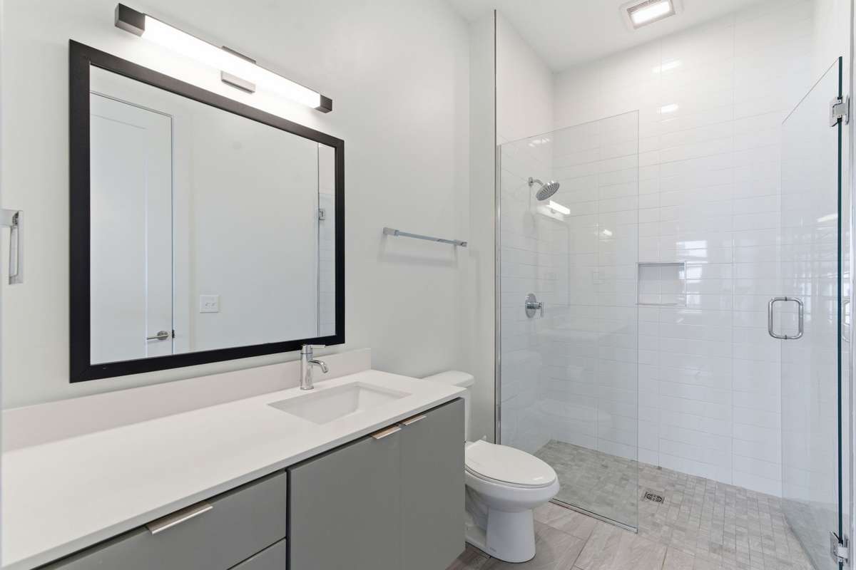 Clean, bright tiled bathroom and shower.
