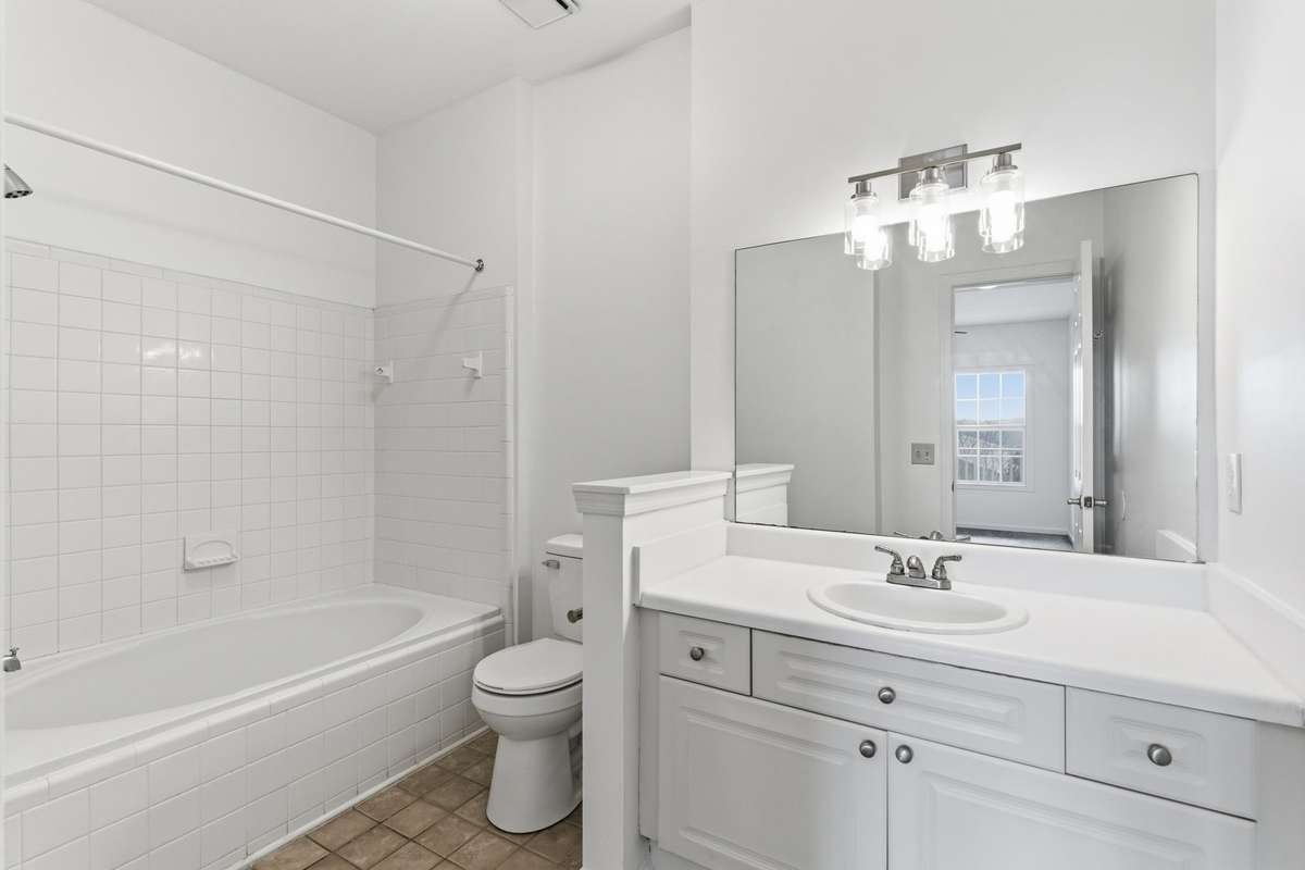 Primary bathroom with a new toilet, freshly painted, new light fixtures - large shower/tub and vanity