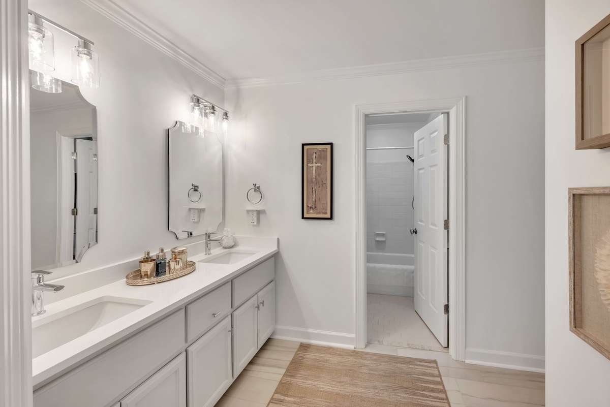The updated full bathroom, with a quartz double vanity, is attached to bedroom 2.