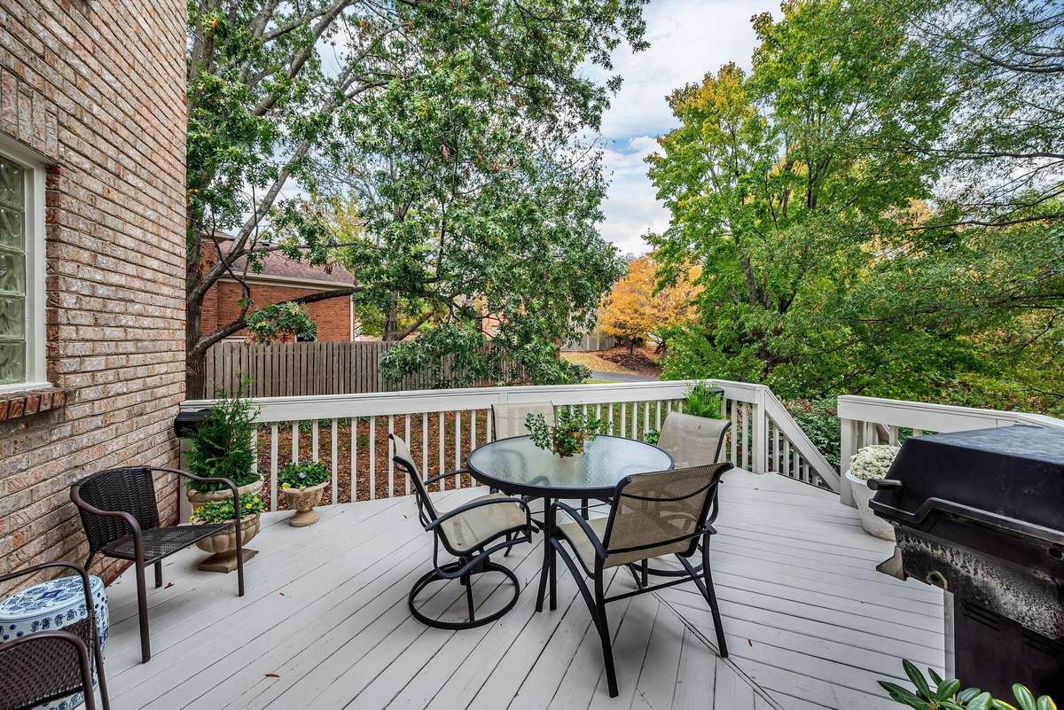 The large deck off the living room is enveloped by mature trees, making it a serene spot for relaxing.