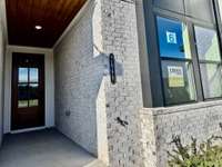 The front stoop covers you with a stained tongue-and-groove ceiling w/ 8' Tall Front Door