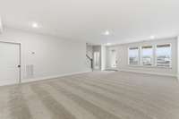 Huge lower level rec room with tons of natural light from wall of windows and patio door that leads to your private outdoor patio.