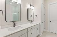 Primary bath with quartz countertops, square designer sinks, designer radius mirrors, black plumbing and hardware and 12 x24 tile flooring