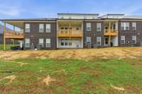 The view of the back of the townhomes with large backyard space.