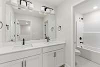 Upstairs bathroom attached to bedroom 3 with quartz countertops, designer square sinks, black plumbing and hardware and 2 sinks!