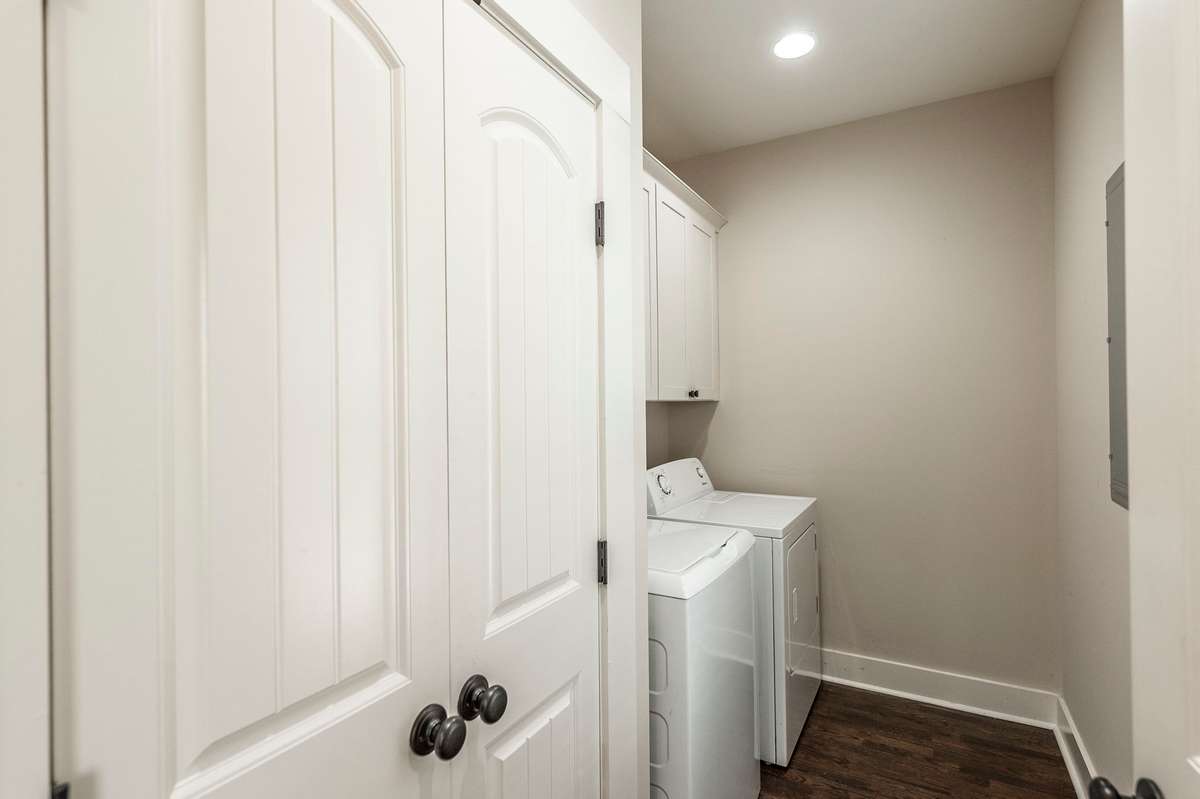 A convenient utility room is located just off the kitchen, enhancing the home’s functionality.