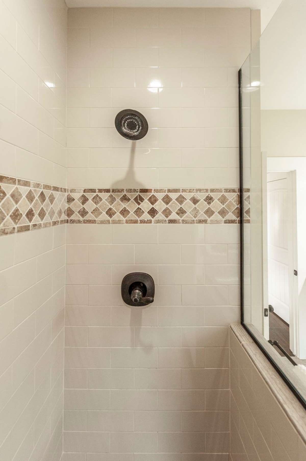 The walk-in shower offers both style and functionality with beautiful tile details.