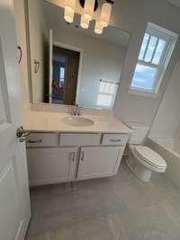 Hall bath with tile floors and quartz counters